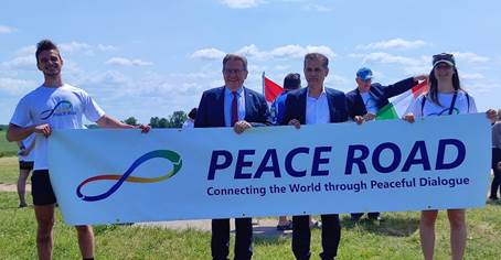 Ist möglicherweise ein Bild von 8 Personen, Straße und Text „PEACE ROAD Connecting the World through Peaceful Dialogue“
