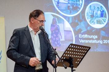 Ein Bild, das Text, Person, Mann, Anzug enthlt.

Automatisch generierte Beschreibung