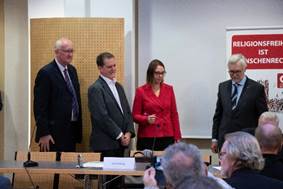 Ein Bild, das Person, Mann, Anzug, Gruppe enthlt.

Automatisch generierte Beschreibung